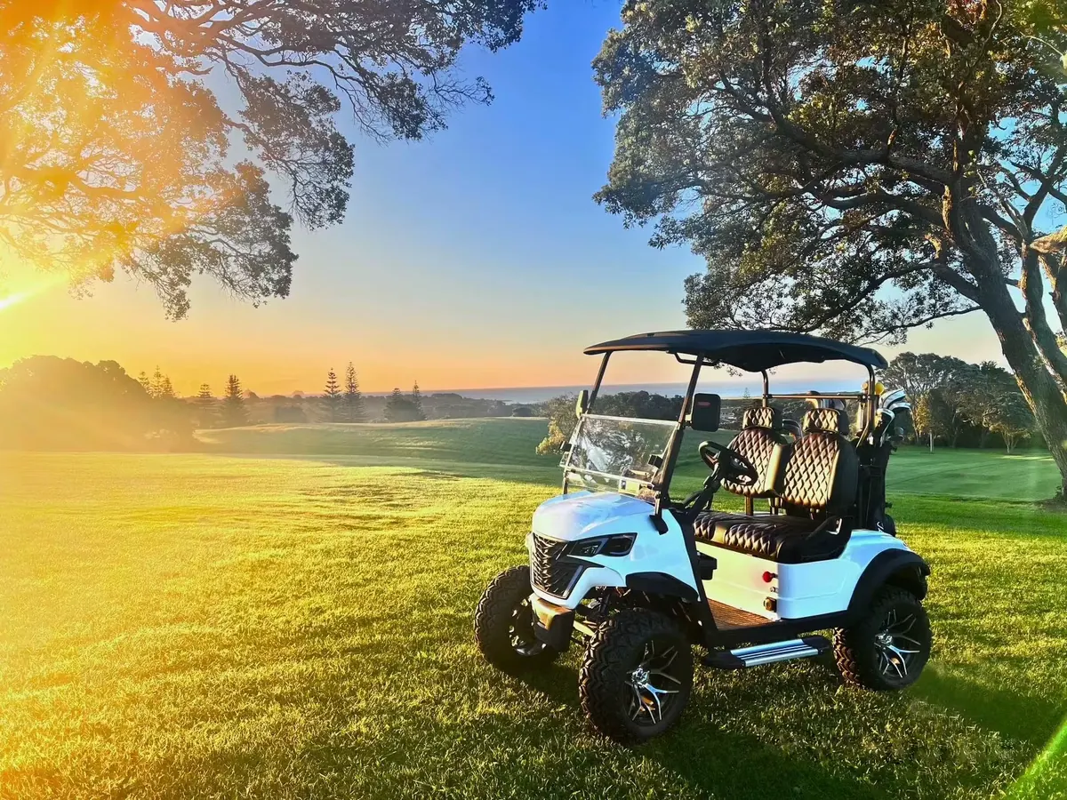 Golf cart on course at sunset